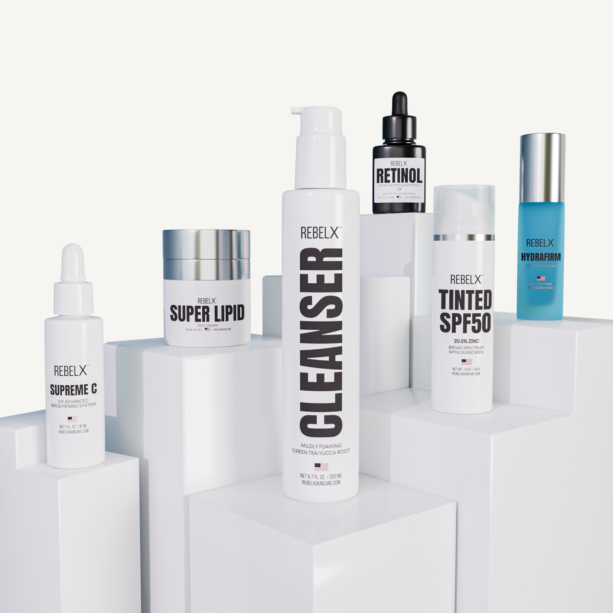 REBELX launch collection featuring Supreme C serum, Super Lipid cream, Cleanser, Retinol serum, Tinted SPF50, and HydraFirm serum displayed on white geometric platforms