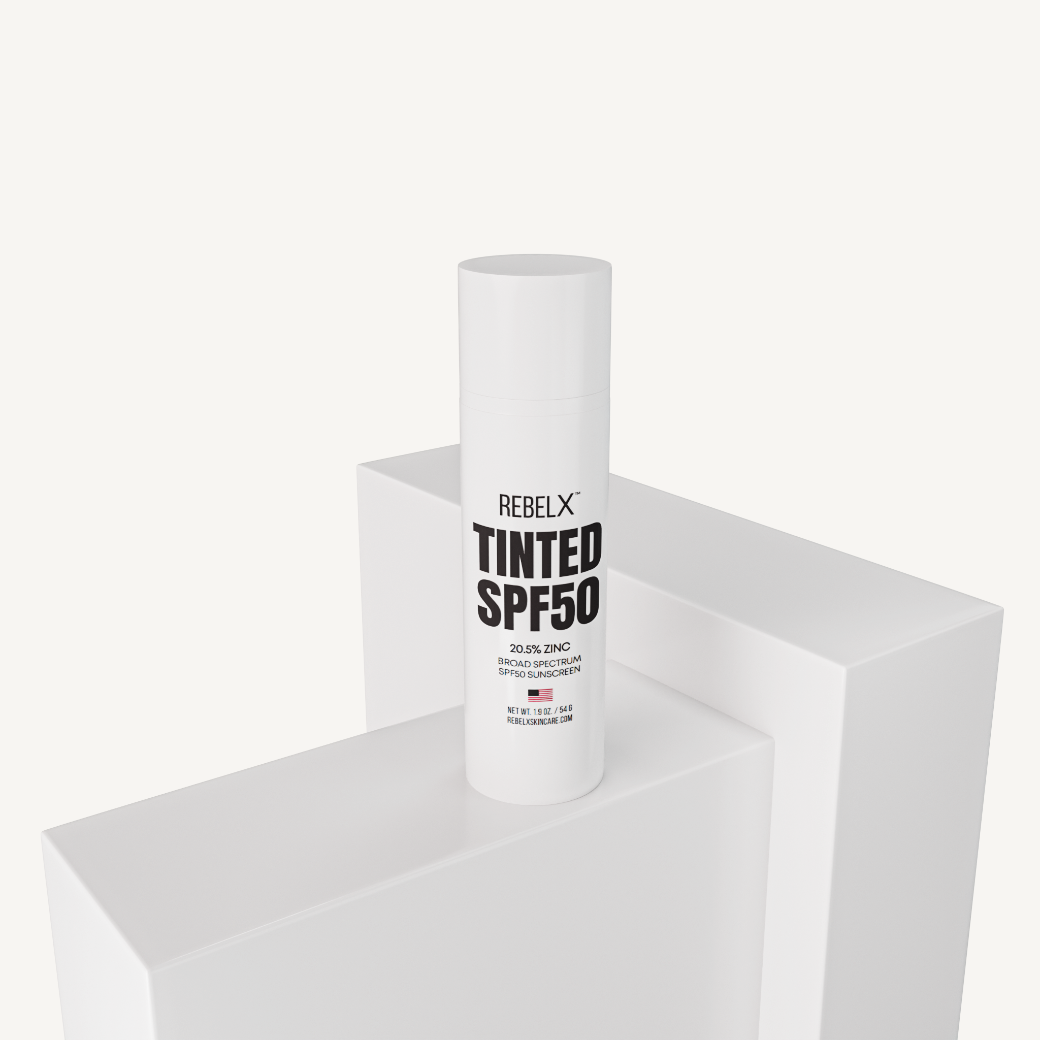 REBELX Tinted SPF50 sunscreen tube with 20.5% zinc displayed on white geometric platforms
